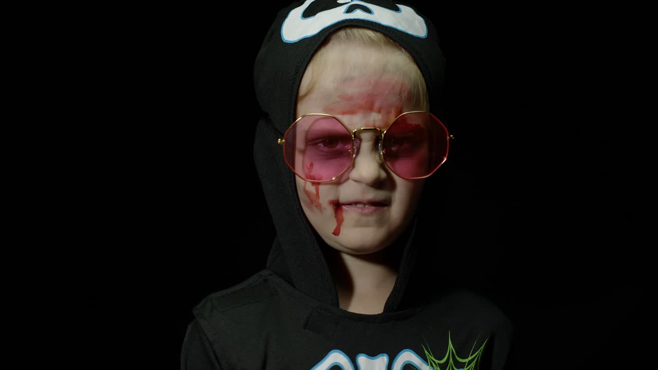 halloween, chica enojada con maquillaje de sangre en la cara. niño vestido como esqueleto aterrador, posando, haciendo caras