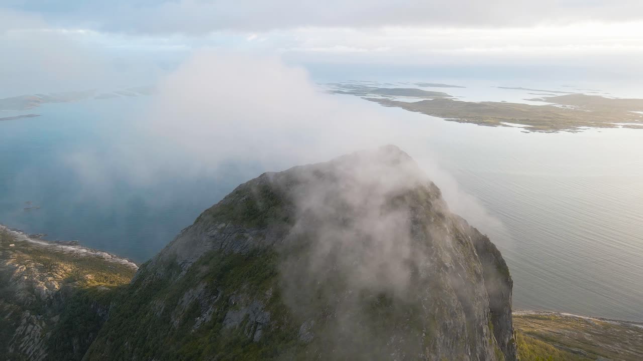 nubes que se mueven sobre picos de montañas y entre montañas con el fiordo en el fondo