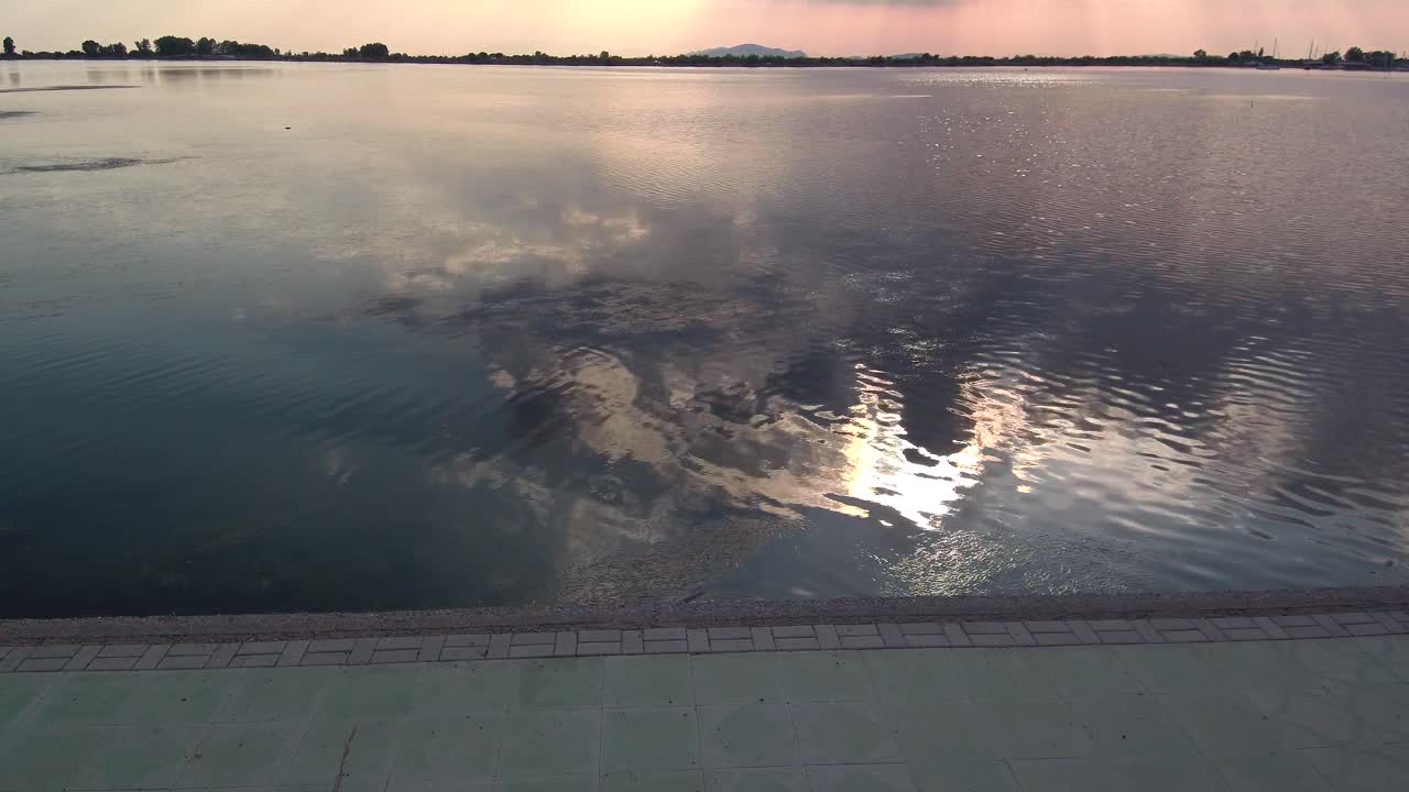 contaminación del agua con el reflejo del sol en el agua gris