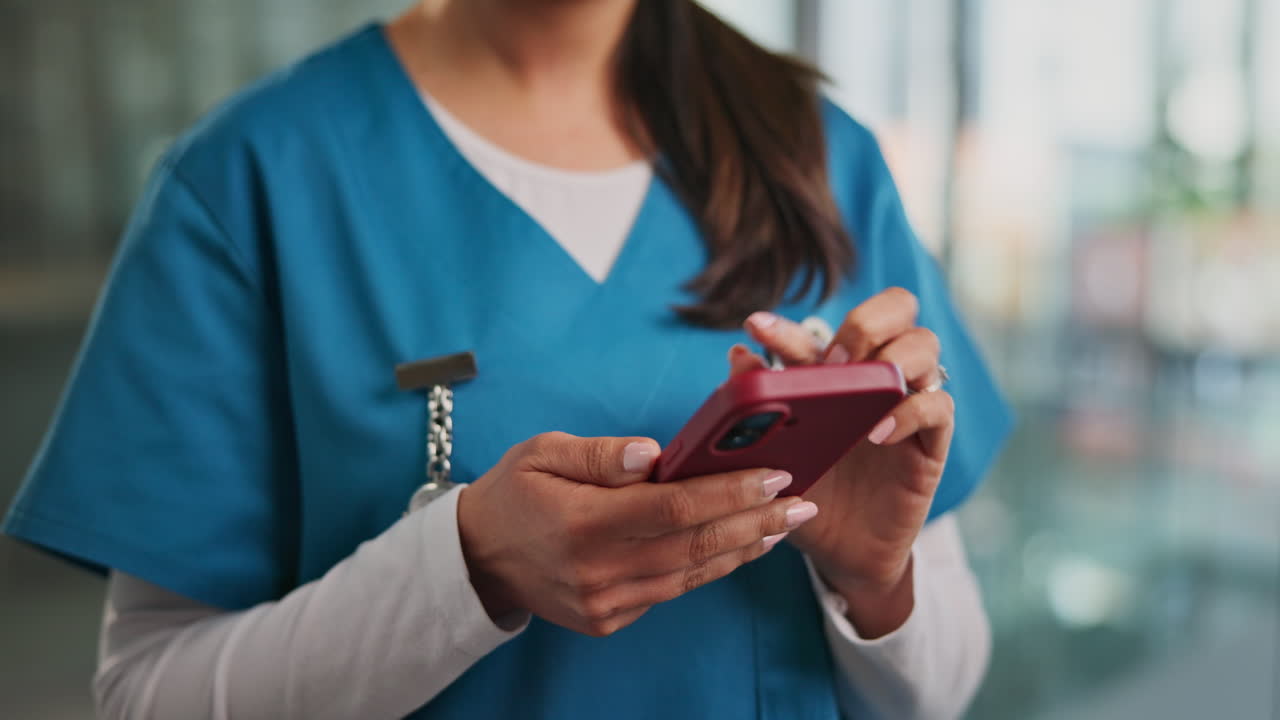 Profesional de la salud usando un smartphone en un entorno médico.