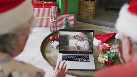 Senior-caucasian-couple-using-laptop-for-christmas-video-call-with-smiling-boy-on-screen