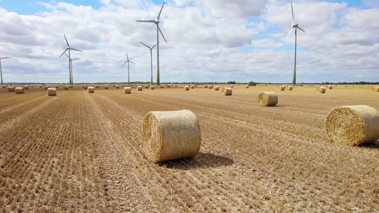 Aerial footage offers a breathtaking sight: a series of wind turbines spinning in a Lincolnshire farmer's freshly harvested field, with golden hay bales as a foreground