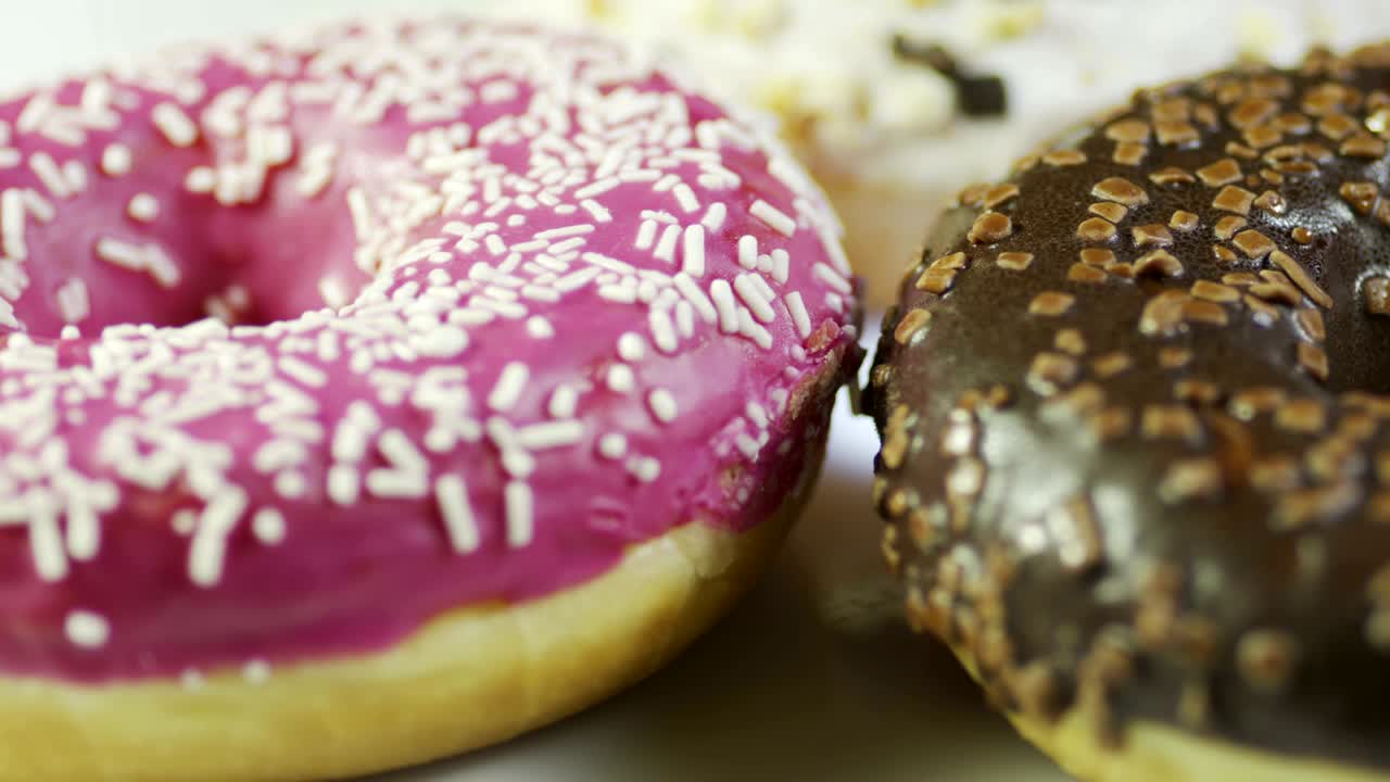 pasteles recubiertos de chocolate y frambuesa rosquilla girando en la mesa