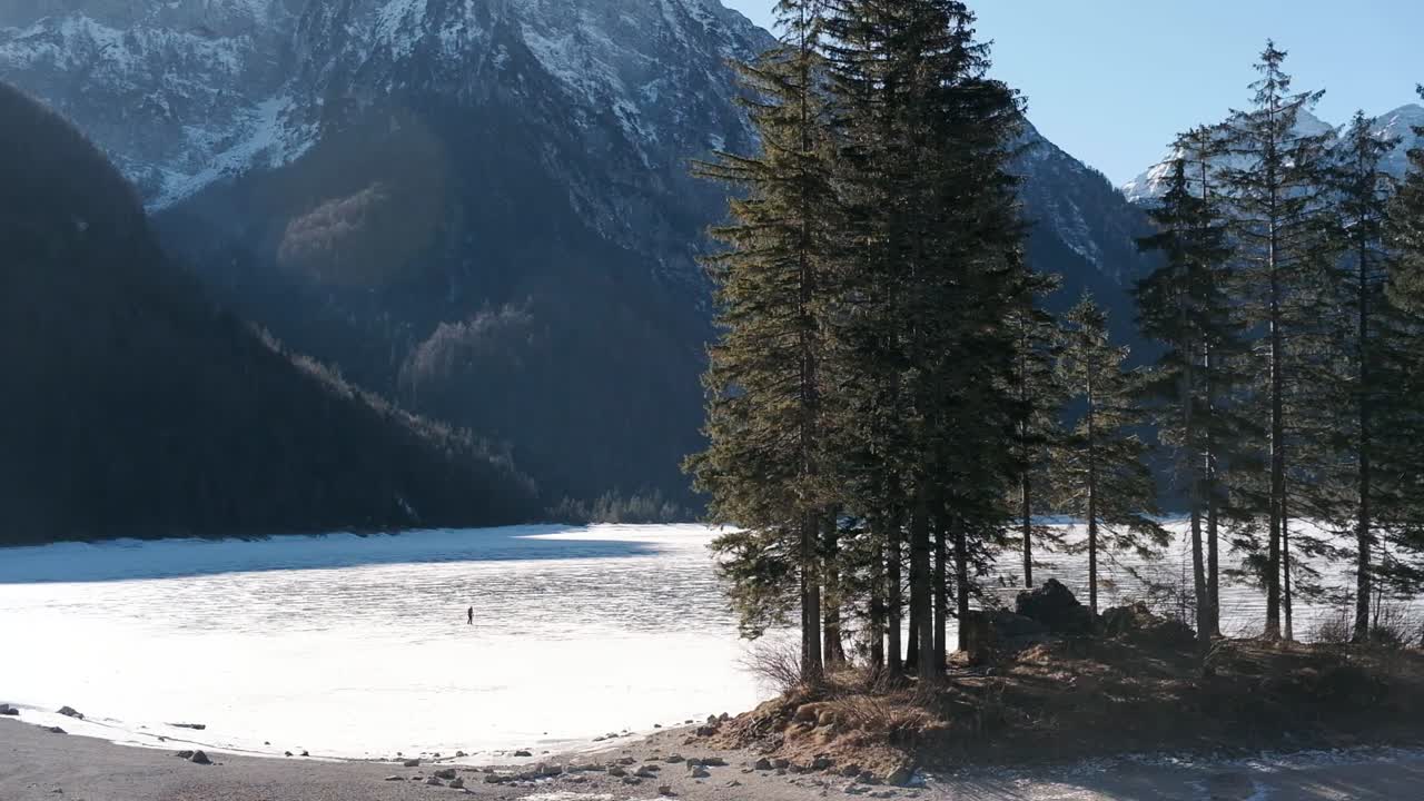 Lago del Predil, Tarvisio – Italia: en frossen alpesjø i et snødekt, vinterlig eventyrfjellandskap.
