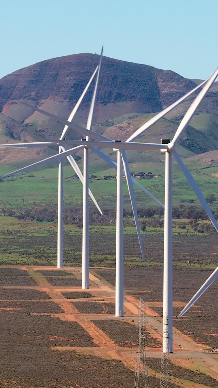 Vertical aerial telephoto zoom shot of wind turbines with hills near Port Augusta, South Australia