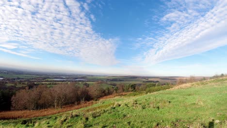 breezy autumn coloured woodland countryside time lapse clouds casting shadows over rural landscape