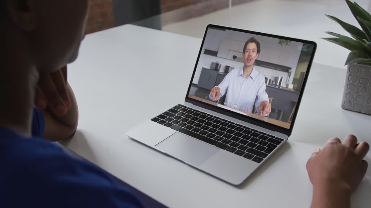 Mid section of african american woman having a video call with male colleague on laptop at office
