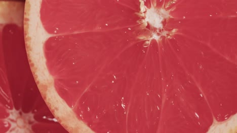 Micro-video-of-close-up-of-red-grapefruit-slices-with-copy-space