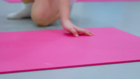 close-up of child hands on a pink exercise mat after slipping from a green stability ball, focus on balance, grip, and physical activity in a gym setting with soft flooring for safety