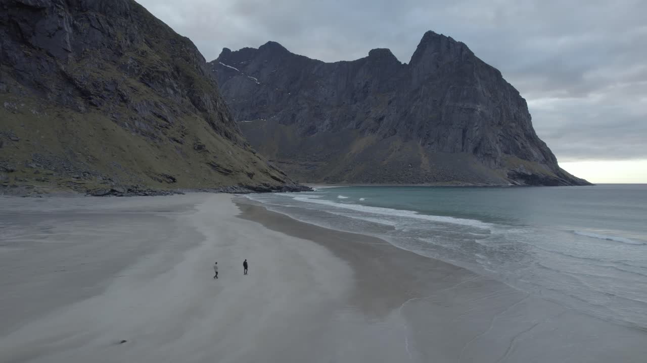 노르웨이 로포텐의 흐린 로포텐에 있는 크발비카 해변을 걷는 사람들의 공중 전망 - 추적, 드론 샷