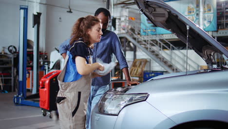 engineer in garage cleans customers car