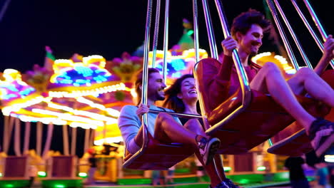 couple enjoying a swing ride at a night carnival