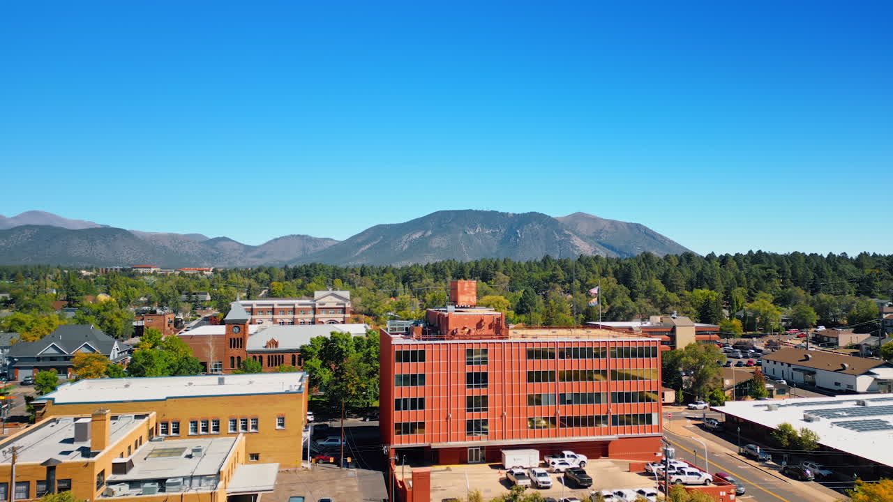 Flagstaff, USA, 24 August 2025: City in lush greenery with mountains at backdrop. Sunny day footage of Flagstaff, Arizona, USA from drone