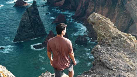 man standing on a cliff overlooking the ocean