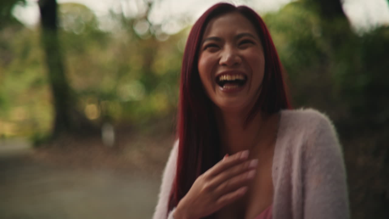 Portraits of a smiling woman with red hair outdoors