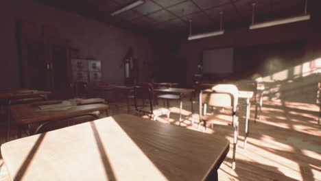 view to classroom with tables and small blackboard and grungy walls