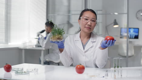 technologist in lab with gm plant and vegetables