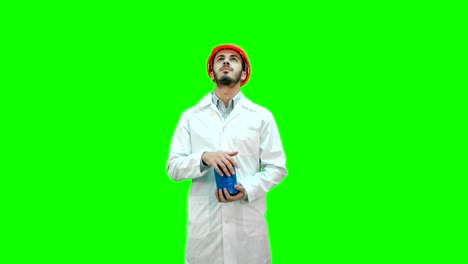 ingeniero con casco y bata blanca lanzando demolición en una pantalla verde, llave croma