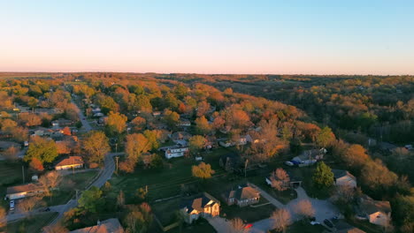 drone ascending over a residential missouri neighborhood at golden hour with vibrant orange autumn trees and scenic suburban views in smooth cinematic hd footage