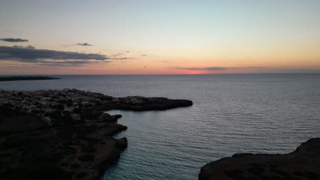 breathtaking view of sunrise and golden sky on the horizon from the sea near s'illot in mallorca, spain. aerial