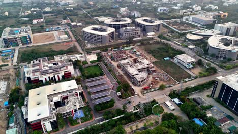 an aerial view of a large complex, a business or technology park, featuring numerous buildings in various stages of development. visible solar panel installations on the ground some of these buildings