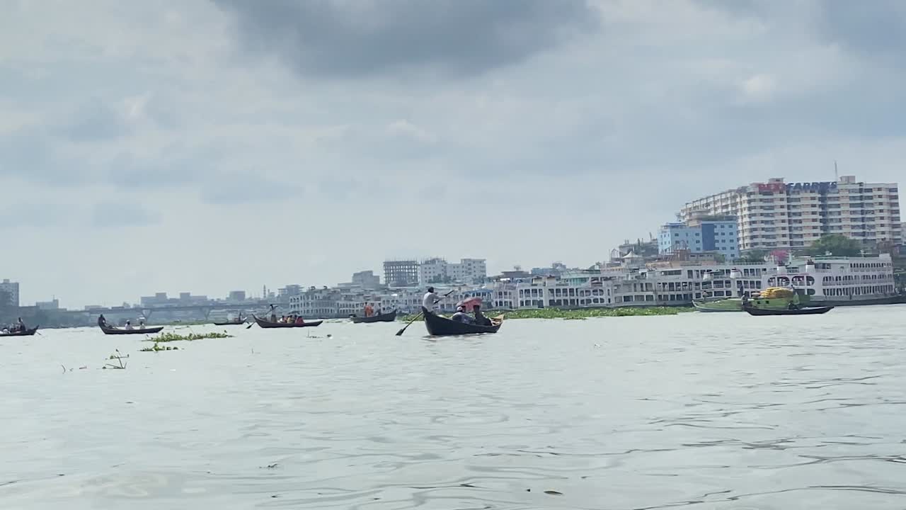 Shikara and Donga boats paddle through large body of water in Bangladesh. Third world country with rich culture and history