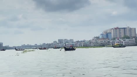 shikara and donga boats paddle through large body of water in bangladesh. third world country with rich culture and history