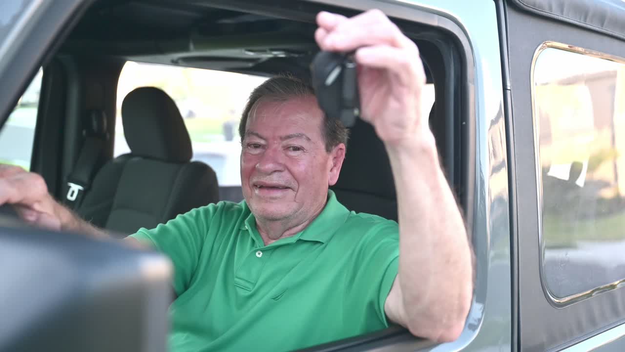 hombre con camisa verde colgando llaves de coche o camión en un vehículo nuevo que compró en el concesionario de coches