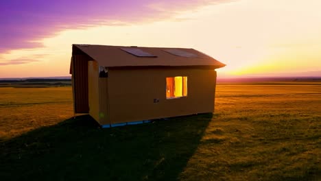 una casa de cartón en un campo al atardecer