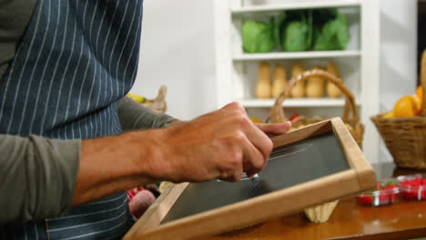 Male-staff-writing-on-slate-in-organic-section