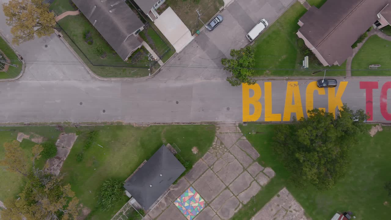 Bird eye view of a large "Black Towns Matter" sign painted on street in Houston Historical independence Heights district