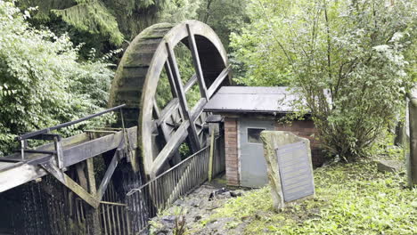 la rueda de un antiguo molino de agua es impulsada por el agua de un arroyo