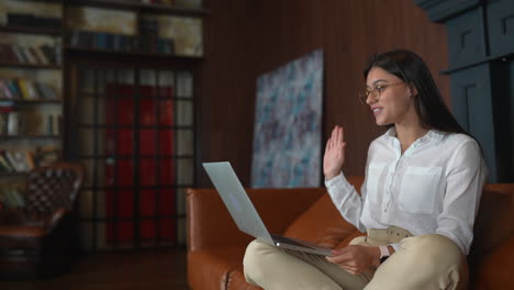 mujer trabajando en una computadora portátil en un sofá