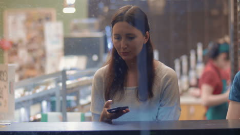 young woman writing messages in smartphone