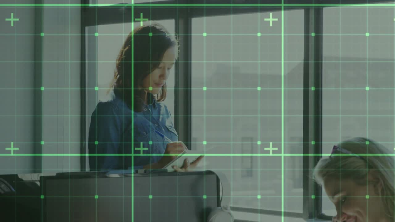 Seated staff lifting smartphone calling with grid while colleague reviewing data on office tablet