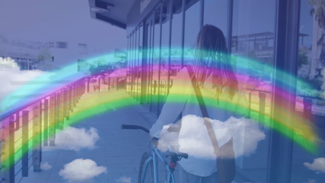man pushing bicycle on walkway, overlaying rainbow arch and drifting clouds for technology design