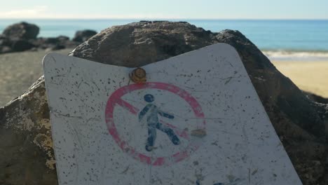 pictogram of a dirty not for public access signage screwed on the rock - palm beach, gold coast - queensland, australia - close up