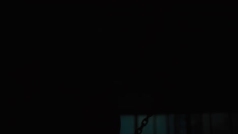 person in protective gear with chains in dark room