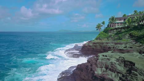 aerial view of rocky cliffs and crashing waves in oahu on a sunny day