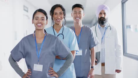 portrait of diverse doctors and nurses smiling in corridor at hospital, in slow motion
