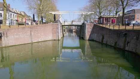 la gente cruza el puente peatonal sobre el canal holandés