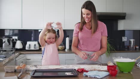 caucasian mother and daughter having fun cooking together