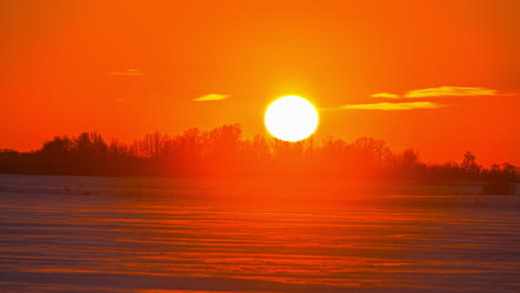 Time-lapse-on-close-up-view-of-the-sun-setting-down-in-the-orange-view-with-clouds-moving-background