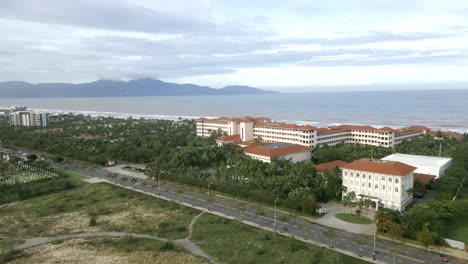 Flyover-from-the-mountains-to-Ha-My-Beach-on-a-cloudy-day-with-wave-hitting-the-shore