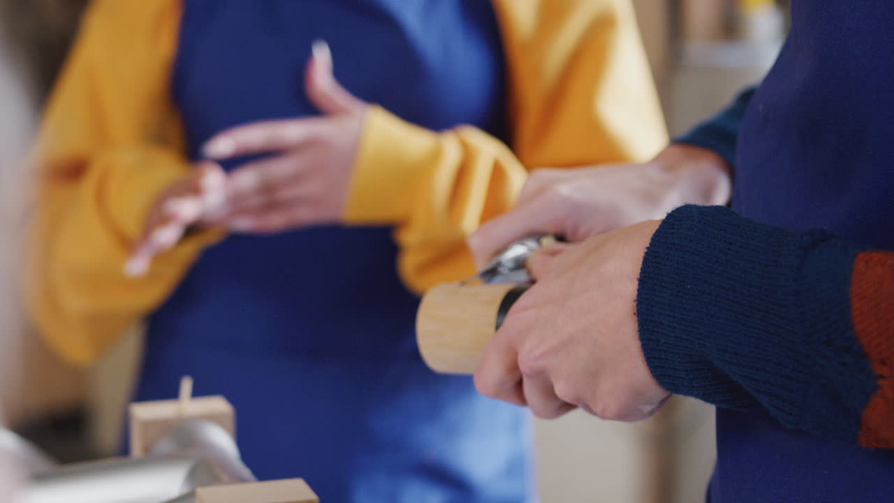 수작업으로 제작된 지속 가능한 대나무 자전거 프레임을 조립하는 워크 ⁇ 에서 다문화 팀의 클로즈업