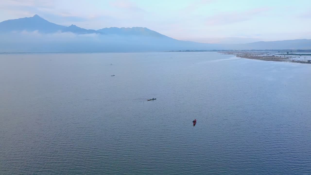 물고기를 잡는 동안 카누에서 멀리 떨어진 곳에서 그물을 던지는 어부들의 공중 전망