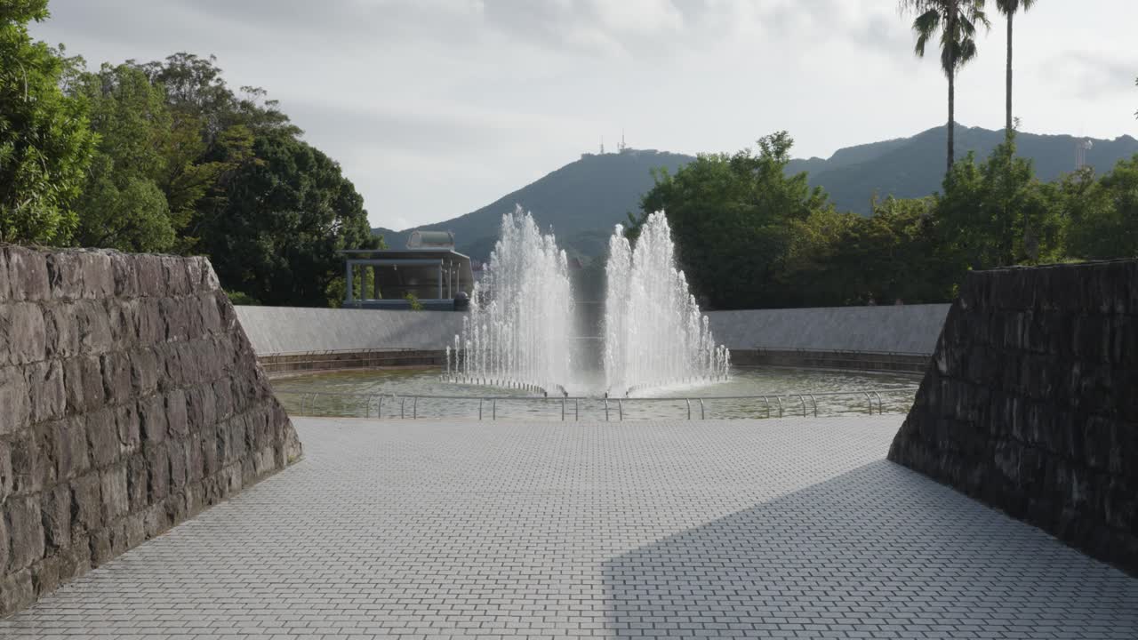 Fuente en el Parque de la Paz de Nagasaki en un día soleado de verano con el monte Inasa al fondo, Japón