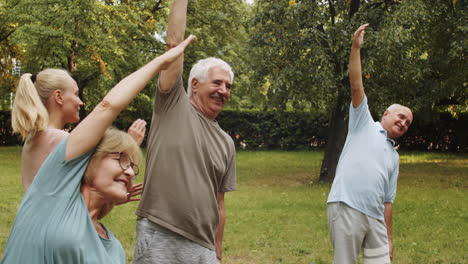 female fitness coach helping senior people during outdoor workout