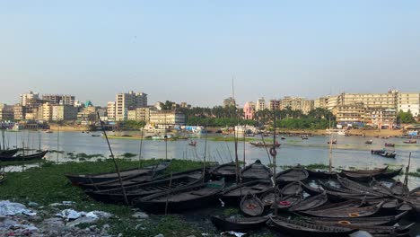 buriganga river with wooden boats wharf and city view, environment pollution concept