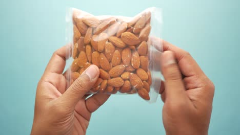 hands holding a bag of almonds